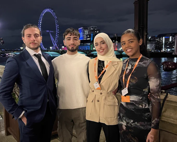 Four people stood infront of the London eye.