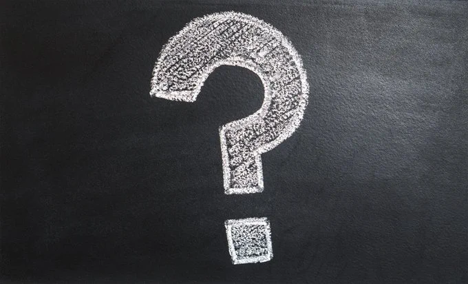 A white question mark drawn in chalk on a blackboard
