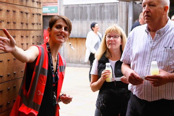A volunteer steward welcomes guests into the Globe Theatre. 
