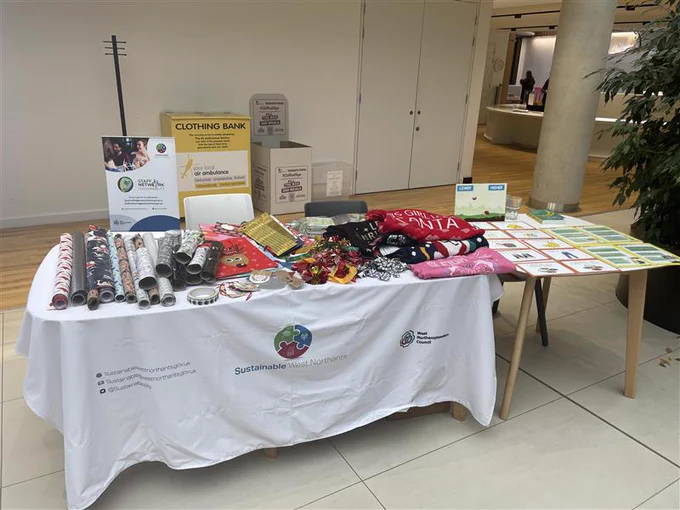 Table showing Christmas wrapping items and jumpers