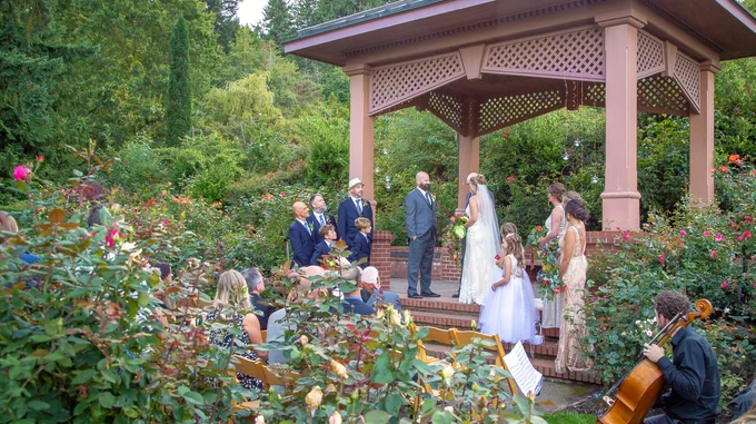 A wedding taking place at a garden inside of a Park.