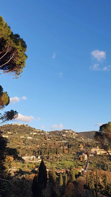 Glowing tuscan hills. The trees are autumnal colours except for the evergreens. The hills of Fiesole can be seen from a hilltop on the edge of Florence, Italy.