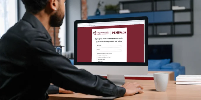Someone sitting at a desktop computer with the PSHSA subscription form up on the screen