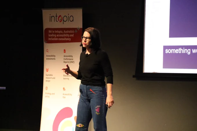 Ally Tutkaluk on stage presenting at A11y Camp.