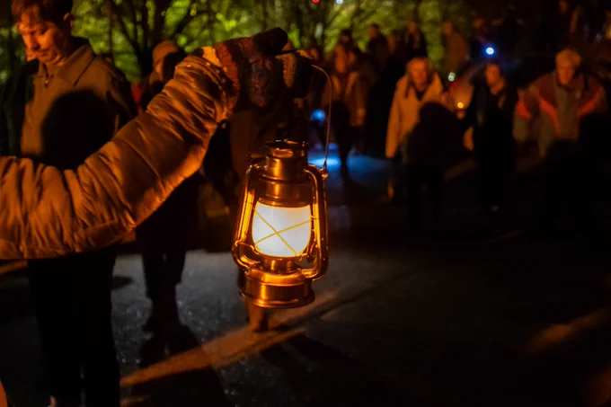 A lit lantern being held in the dark