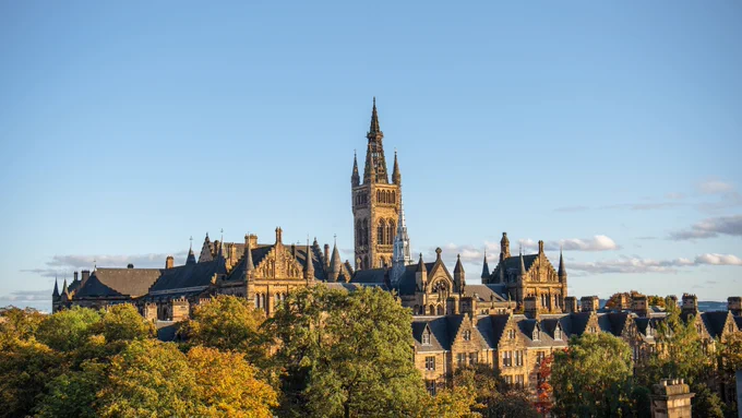 The Gilbert Scott building at the University of Glasgow surrounded by trees.