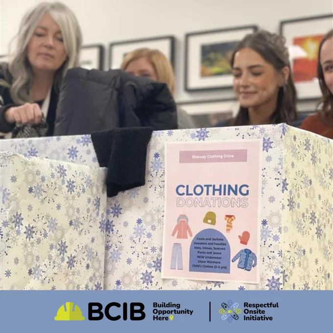 Four individuals participating in a clothing donation drive organized by BCIB. One person is placing a garment into a donation box adorned with a colorful pattern and signage detailing acceptable items for donation.