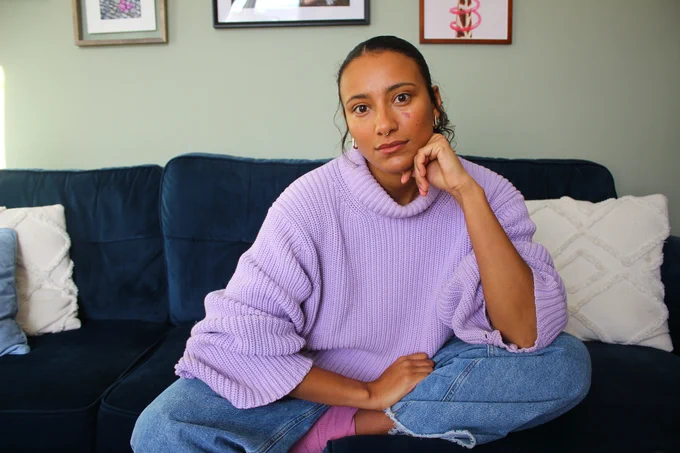 Journalist Mary Mandefield seated on a sofa and looking towards camera