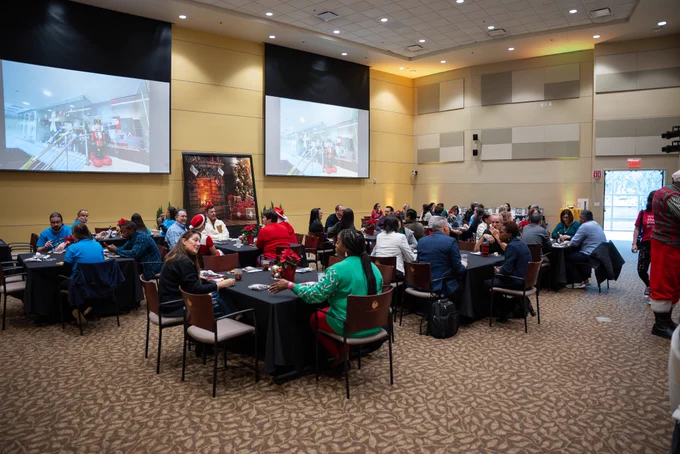 Faculty and staff in the UCF College of Community Innovation and Education sitting and enjoying food and drinks at the college's holiday gathering.
