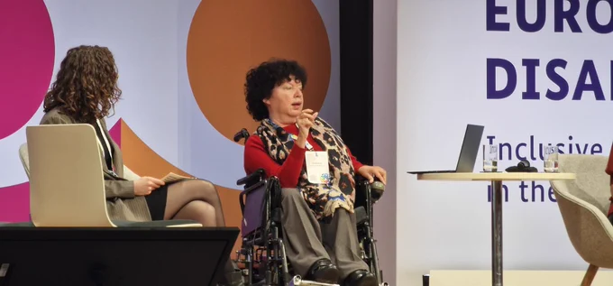 Gunta Anca, vice-president of the European Disability Forum, on the stage of the European Regional Disability Summit in Berlin. To her left is Lydia Vlagsma, co-chair of EDF's youth forum.