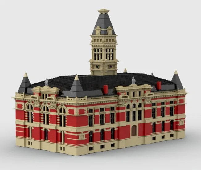 A rendered LEGO model of Washtenaw County's lost courthouse, red brick with limestone details, pointed towers at the corners, and a large tower in the center, set against a white background.