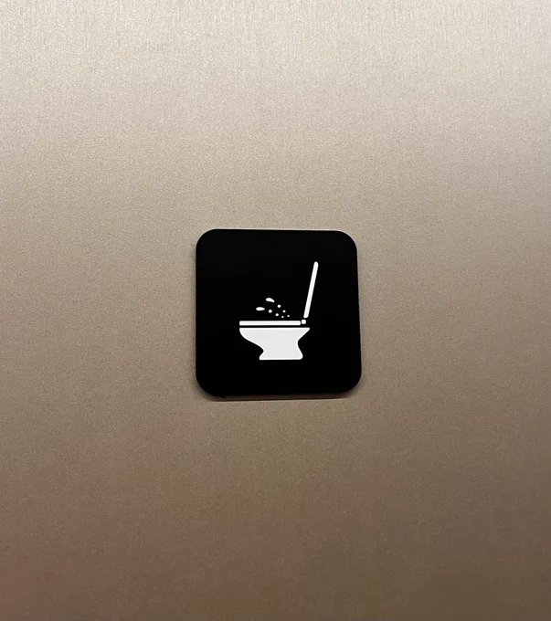 Bidet icon on an airport bathroom stall door