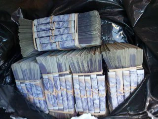 Stacks of seized cash in a bag