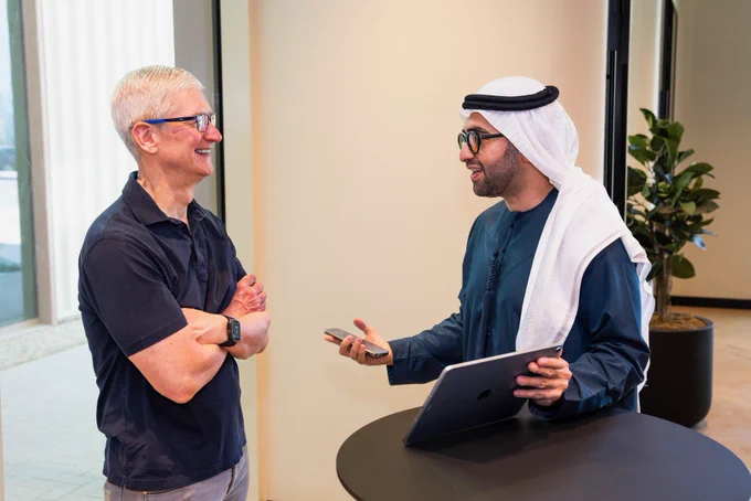 The developer of Big Keys stands behind a tall, round, black table, with iPhone and iPad in his hands, talking with Tim
