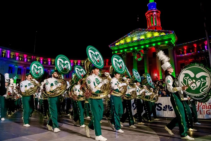 C S U tuba and bass drum marching band members marching in the 9 News Parade of Lights past the capitol in downtown Denver. 