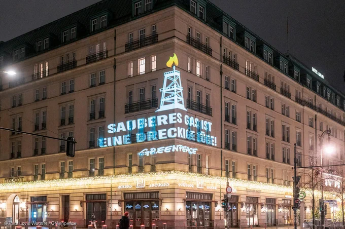 An der Fassade des Hotel Adlon in Berlin steht in den frühen Morgenstunden des 9.12.24 in weißer Schrift "Sauberes Gas ist eine dreckige Lüge" projiziert, darüber ein Bohrturm mit Flammen.