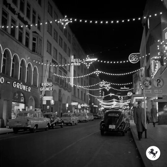 Archivbild der Marienstraße in Stuttgart mit Weihnachtsbeleuchtung über der Straße, parkenden Autos auf der Straße und Personen auf dem Gehweg.