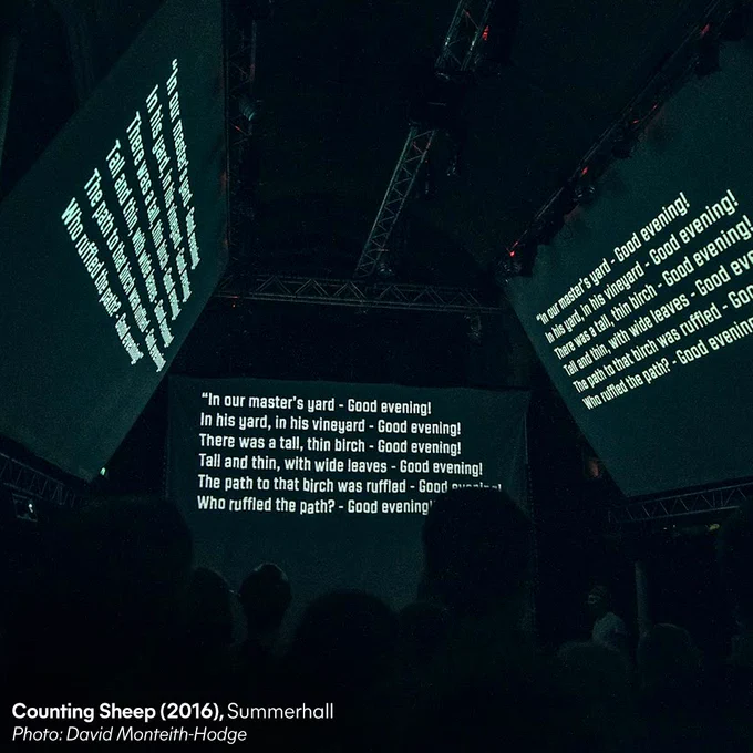 Three screens display text above an audience in a darkened room. Credit text: Counting Sheep (2016), Summerhall. Photo: David Monteith-Hodge.