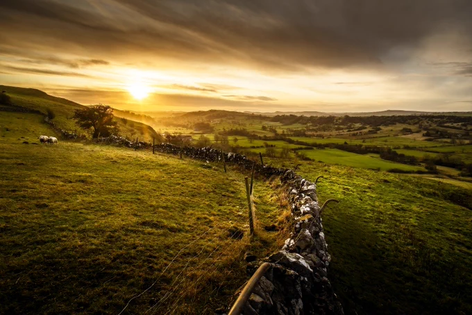 A farming landscape in the hills as the sun sets