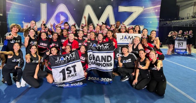 Lincoln High School cheerleaders hold banners that show they are First Place Grand Champions at Jamz Friday Night Lights Cheer Competition