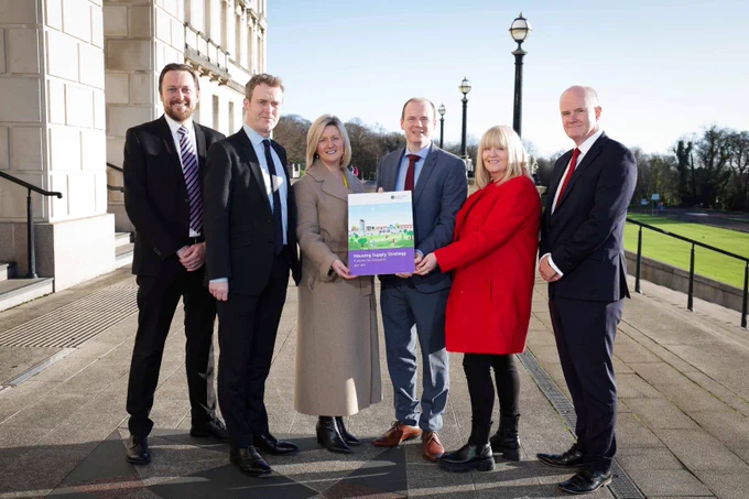 Communities Minister Gordon Lyons marked the announcement of the Housing Supply Strategy at Stormont with co-signatories Seamus Leheny (Northern Ireland Federation of Housing Association), Nicola McCrudden (Homeless Connect), Justin Cartwright (Chartered Institute of Housing Northern Ireland), Grainia Long (The Northern Ireland Housing Executive), and Mark Spence (Construction Employers Federation).  Pictured outside Parliament Buildings