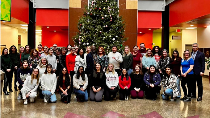 Members of the Offord Centre for Child Learning pose for a holiday image in front of a Christmas tree.