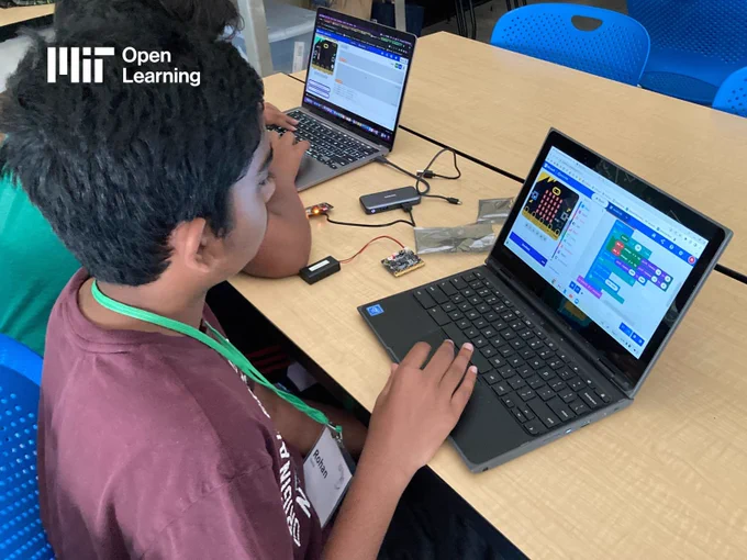 Candid photo of two middle school student coding on their laptops in a classroom setting. The logo for MIT Open Learning is in the corner.