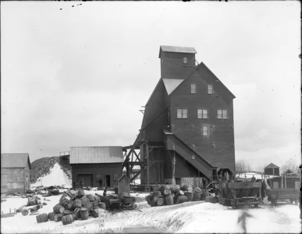 Shafthouse, auxiliary buildings, barrels, and rail cars in the snow