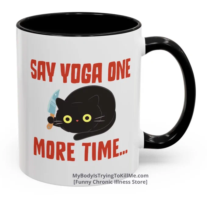 A white mug with black handle with a black cat and kitchen knife and in red text that says    say yoga one more time