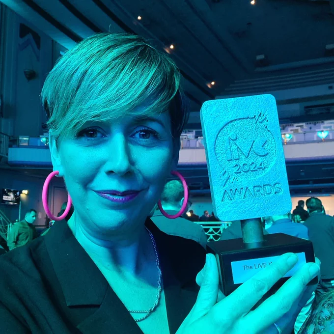 Phoebe holding up the award
