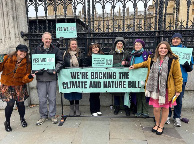 Vikki Slade MP stands outside Parliament with supporters of the climate and nature bill. They hold banners which read “we’re backing the climate and nature bill” and “yes, we can”