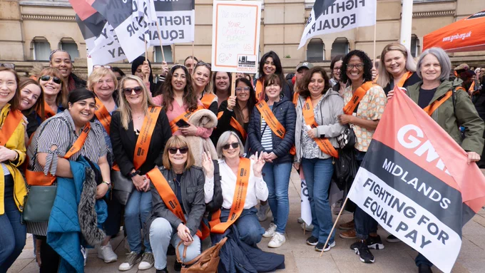 Birmingham City Council workers rally outside the city's Council House with GMB flags and placards calling for equal pay. They are wearing GMB branded orange sashes that call for "pay justice".