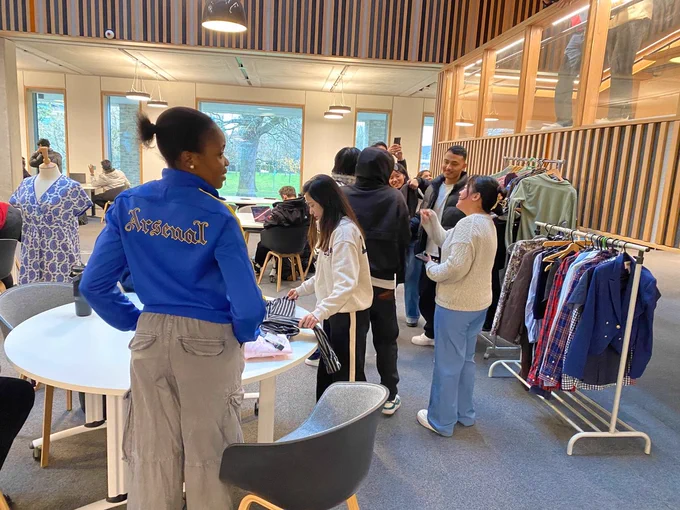 Image shows people looking at clothes and taking photos