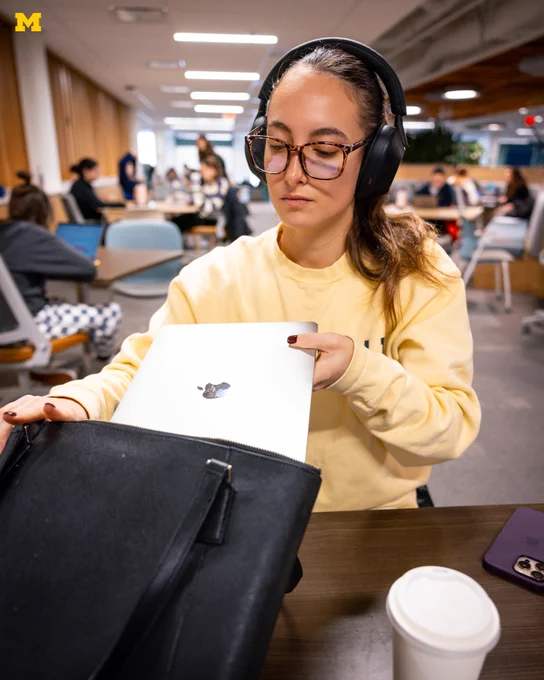A U-M student gets her laptop out to study in Shapiro Library.