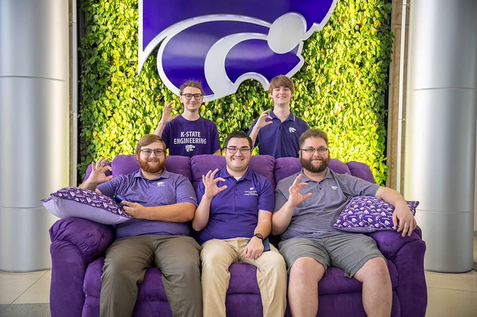 Five E-Club members pose for a photo with the couch.