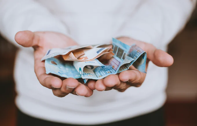 Hands hold out euro notes