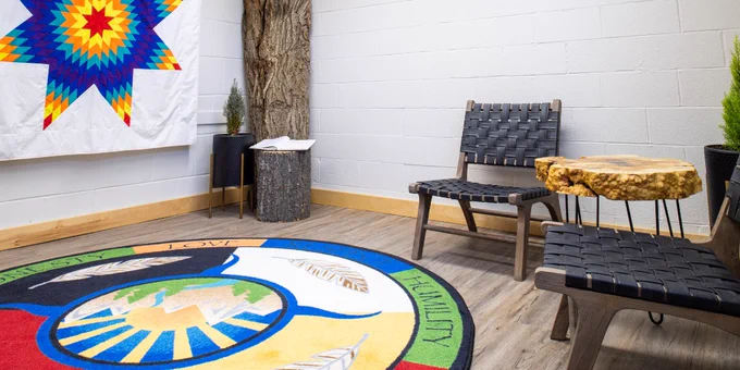 The seating area in the Indigenous Spirit Room with a Star Blanket on display.
