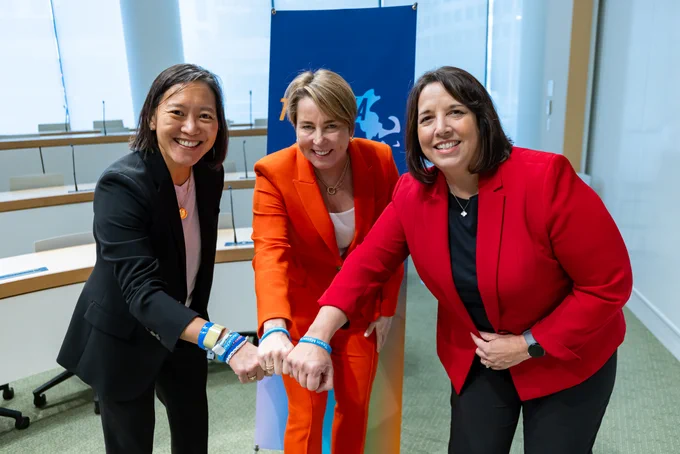 Governor Healey, Lt. Governor Driscoll, and Secretary Hao showing off their Team Massachusetts bracelets.
