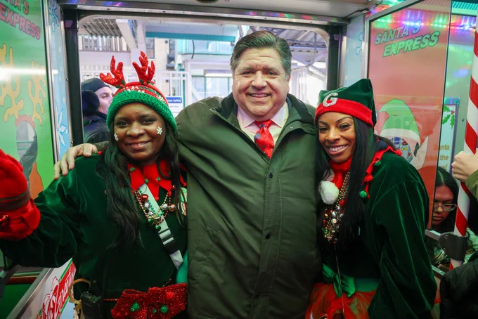 Governor Pritzker takes pictures with the Christmas elves on the Holiday Train.