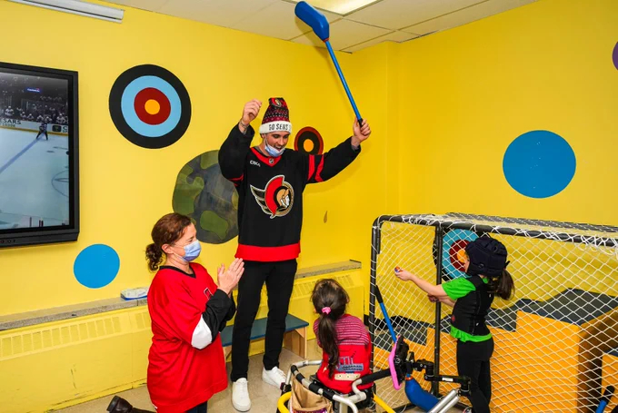 Shane Pinto celebrates a student at CHEO School scoring a goal during a game of floor hockey