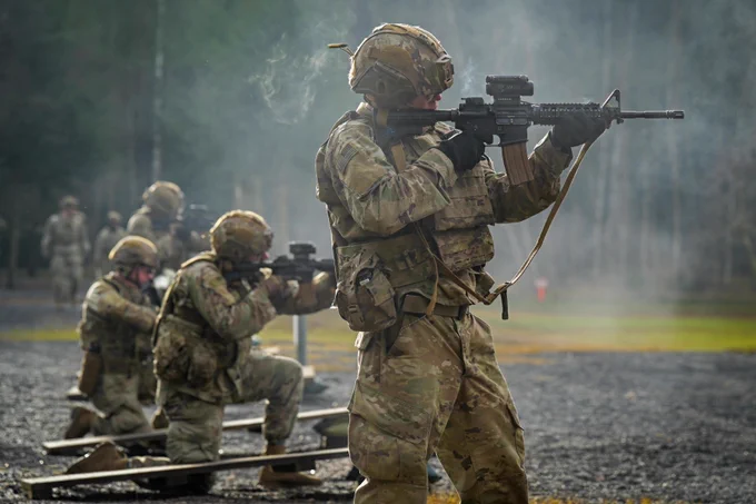 Line of soldiers at a firing range shooting weapons