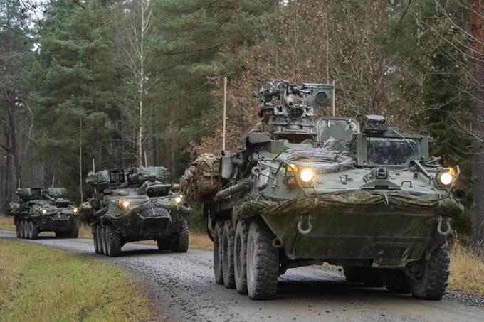 Convoy of Strykers driving through a forest
