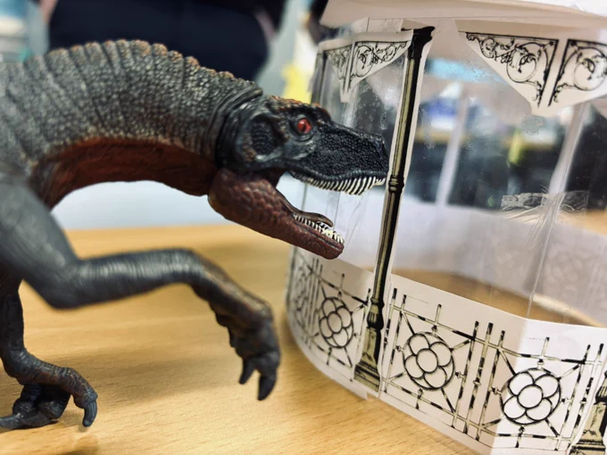 Photo of a toy dinosaur next to one of the pupil’s bandstand models. Menacingly looking into the bandstand like a scene from Jurassic Park!
