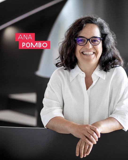 Graphic with image and text. The image is a portrait of [Ana Pombo] a smiling person with glasses and curly hair, leaning on a railing indoors, wearing a white shirt. The text reads "Ana Pombo" and is placed on a red text block. © Pablo Castagnola, Max Delbrück Center