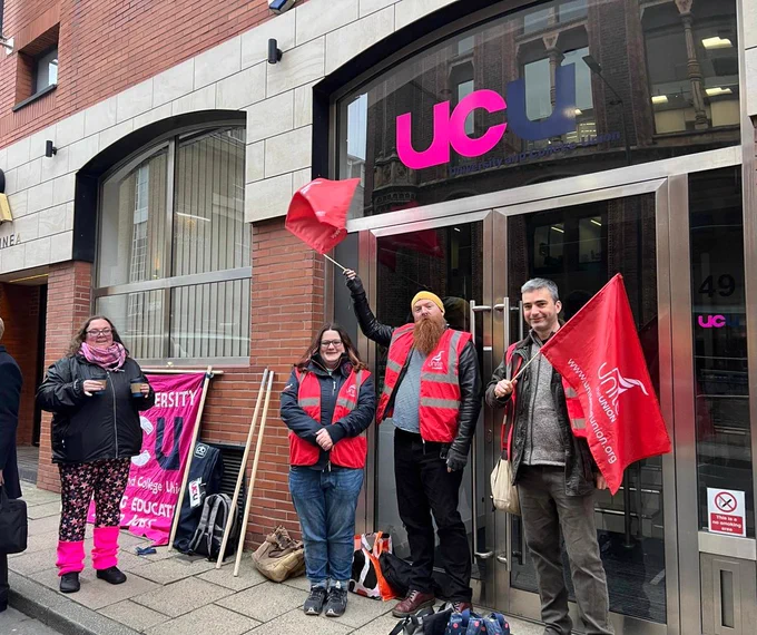 Unite picketers waving Unite flags outside UCU's Leeds office