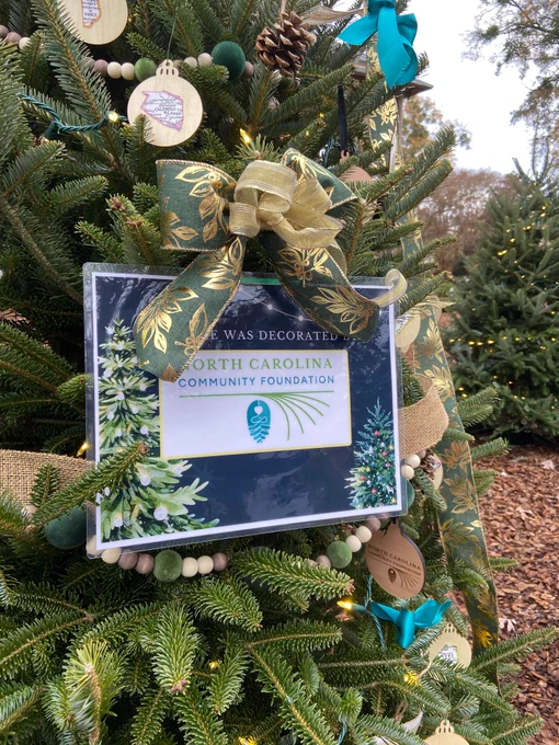 Sign on holiday tree showing the NC Community Foundation logo
