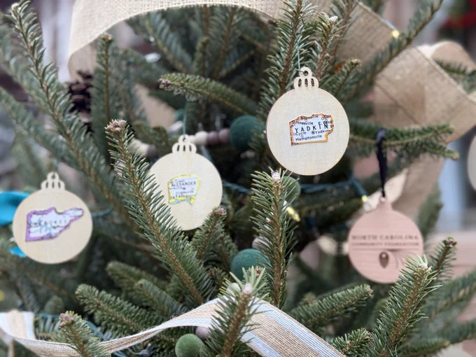 Ornaments on holiday tree showing counties in NC, and the NC Community Foundation logo
