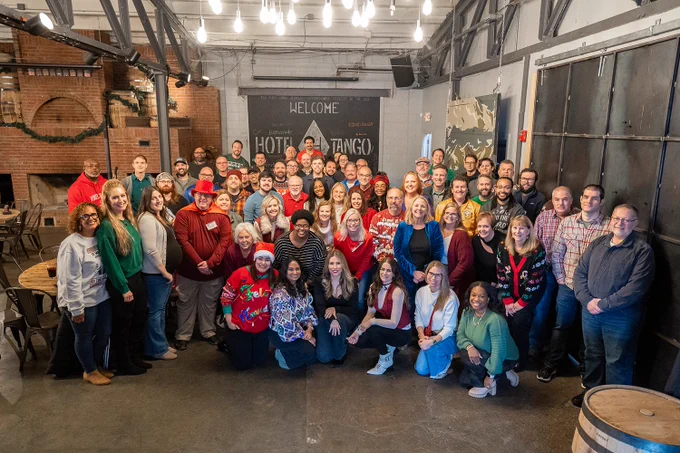 Group of people posing for a photo in a festive gathering at Hotel Tango Distillery.