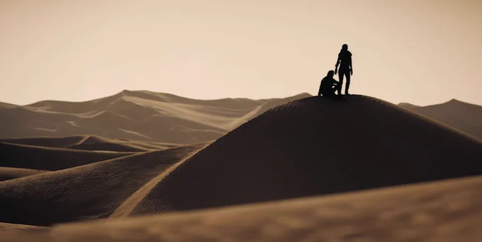 Production still - characters atop a dune on Arrakis.