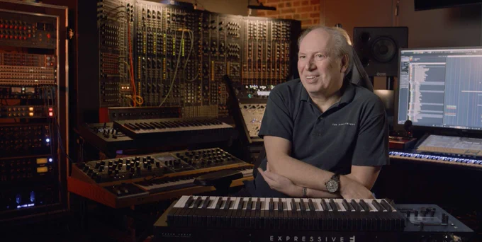 Hans Zimmer, framed by a wall of modular synths and a screen showing Cubase, with Expressive E Osmose keyboard in the foreground.